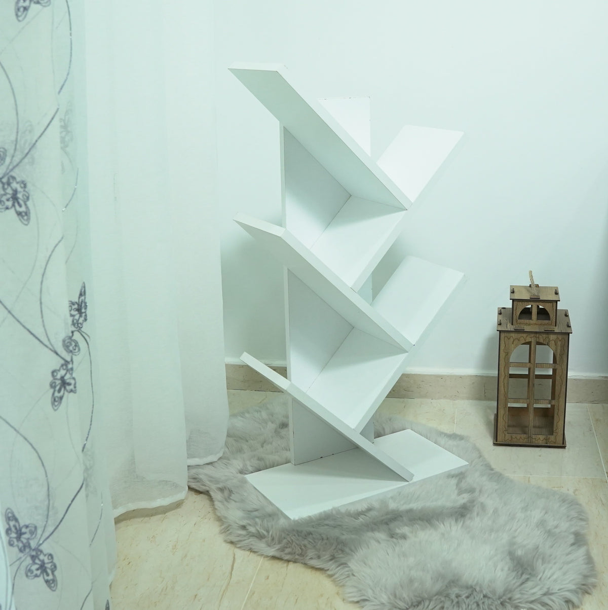 Bibliothèque arbre beige – en situation salon avec tapis et lanterne décorative