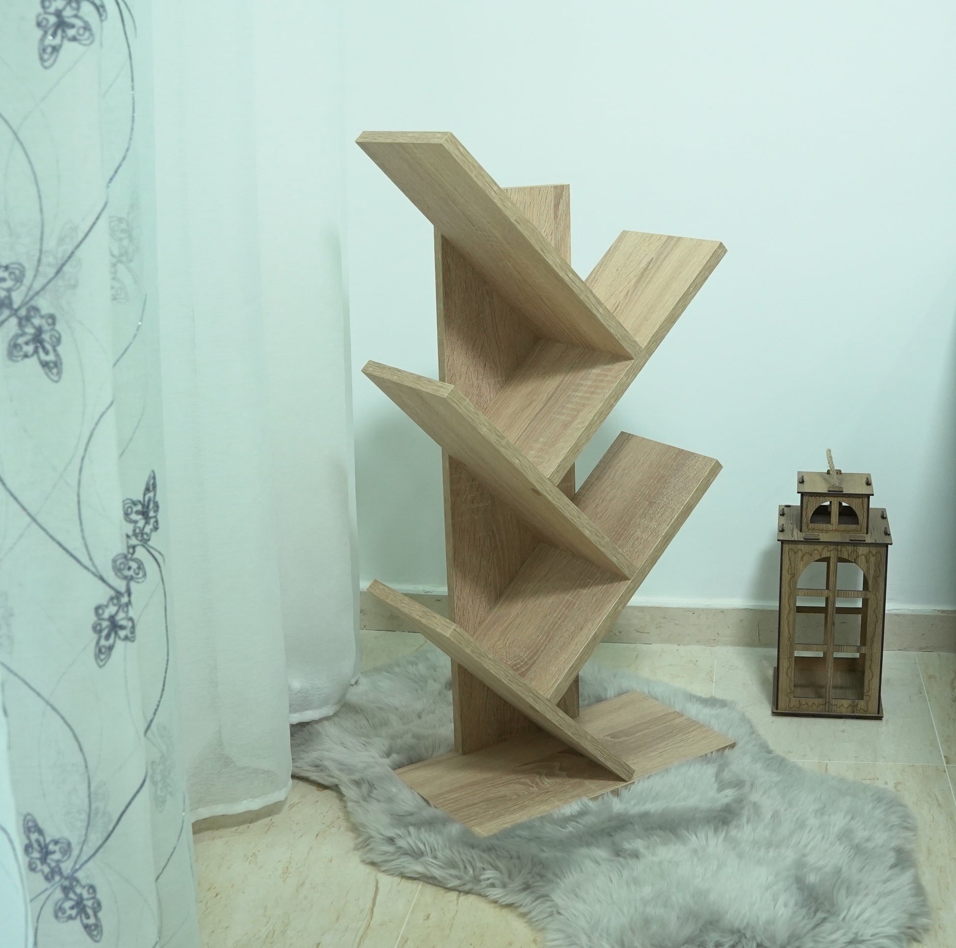 Bibliothèque arbre beige – en situation salon avec tapis et lanterne décorative