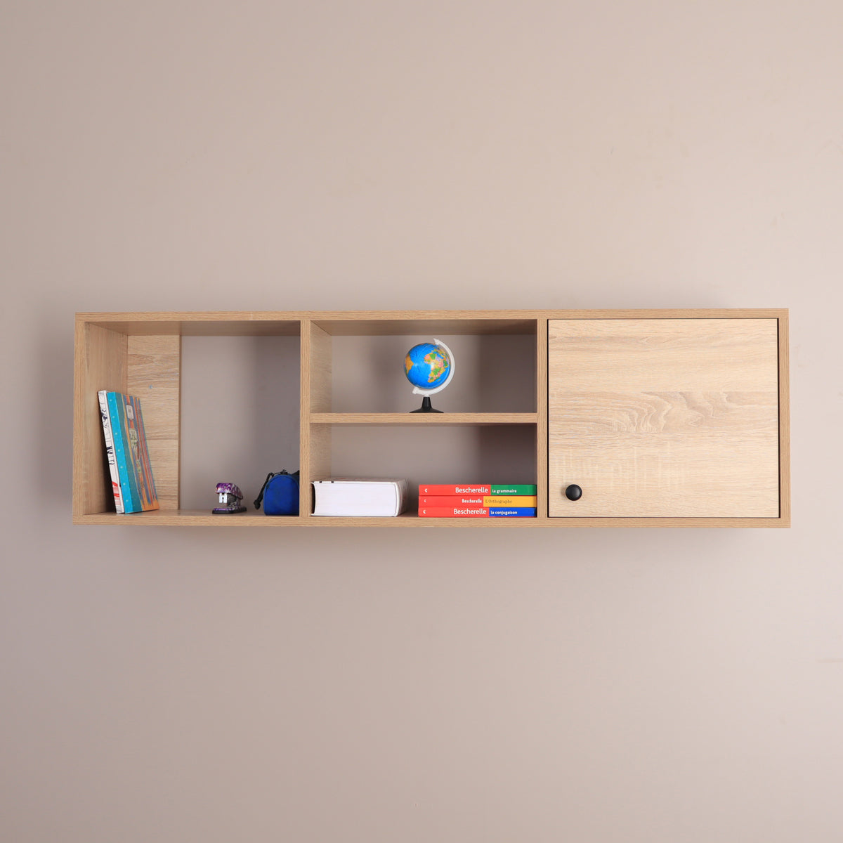 Bibliothèque murale suspendue beige – vue de face avec livres, globe et porte ouverte