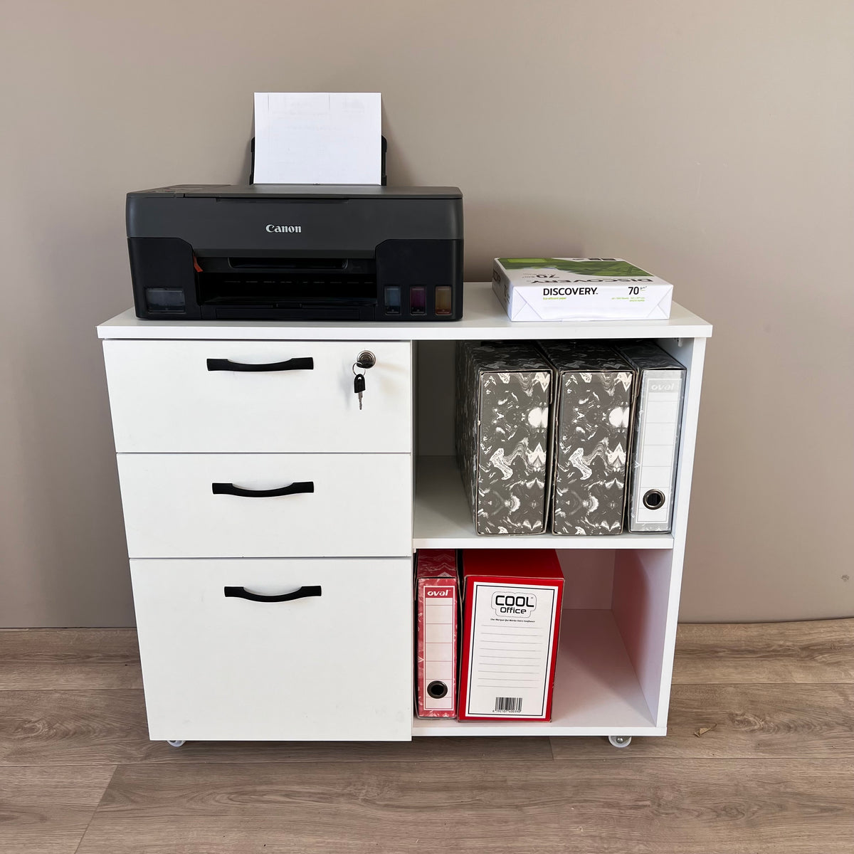 Meuble rangement bureau blanc – vue frontale avec imprimante et classeurs, roulettes visibles